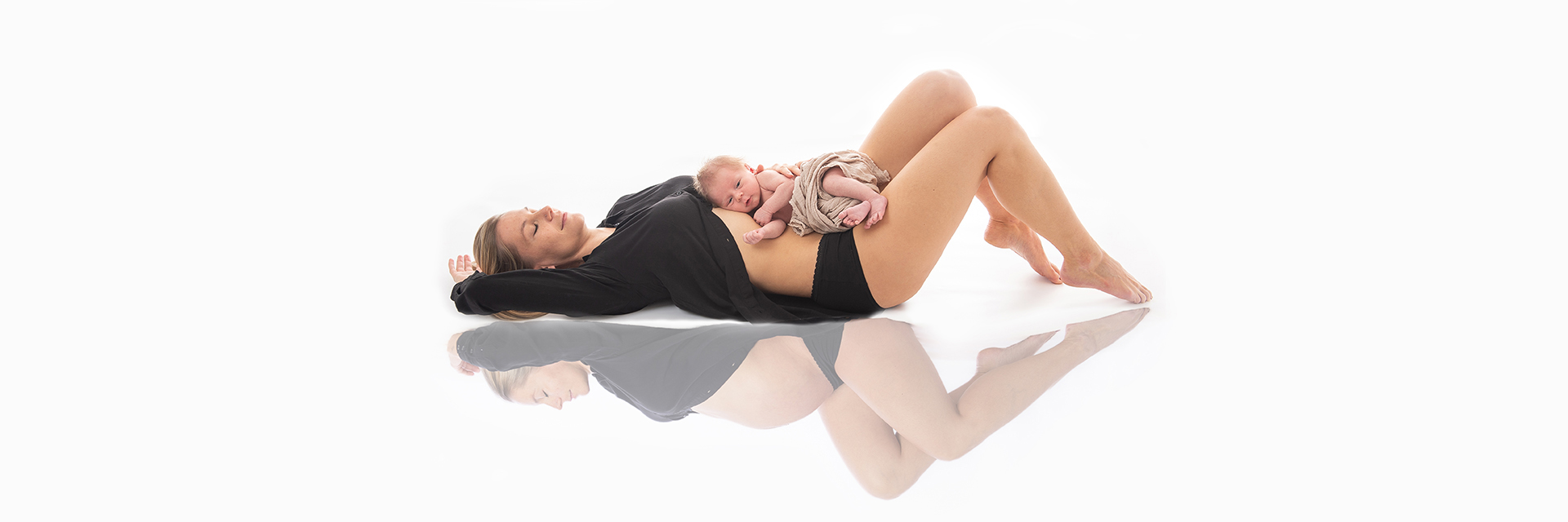 Mutter mit neugeborenem Baby und Spiegelung von Babybauch