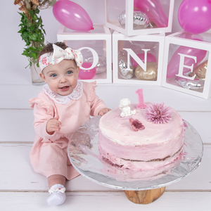 Cake-Smash-Shooting zum Geburtstag mit kleinem Mädchen und rosa Torte