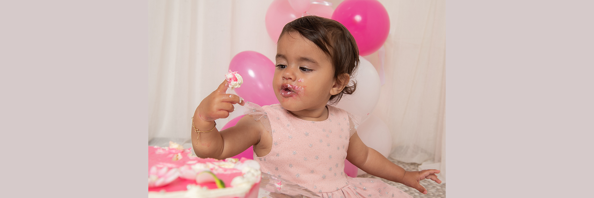 Cake-Smash-Shooting zum Geburtstag mit Mädchen und rosa Torte