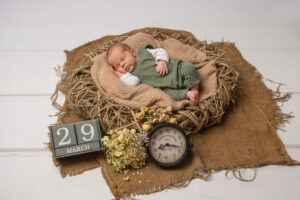 Baby im Korb mit Geburtsdatum und Zeit beim Newbornshooting