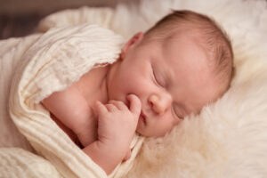Schlafendes Babymädchen auf kuscheligem Fell am Newbornshooting