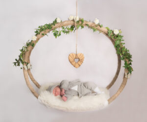 Neugeborenenshooting mit schlafendem Baby in schwebendem Ring