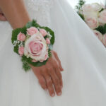 Rosa Hochzeitsblume am Handgelenk der Braut