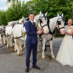 Hochzeitspaar vor Kutsche und sechs weissen Pferden